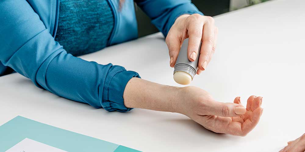 Person applies topical cannabis to wrist