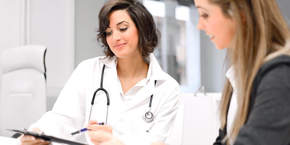 Female doctor speaking to female patient